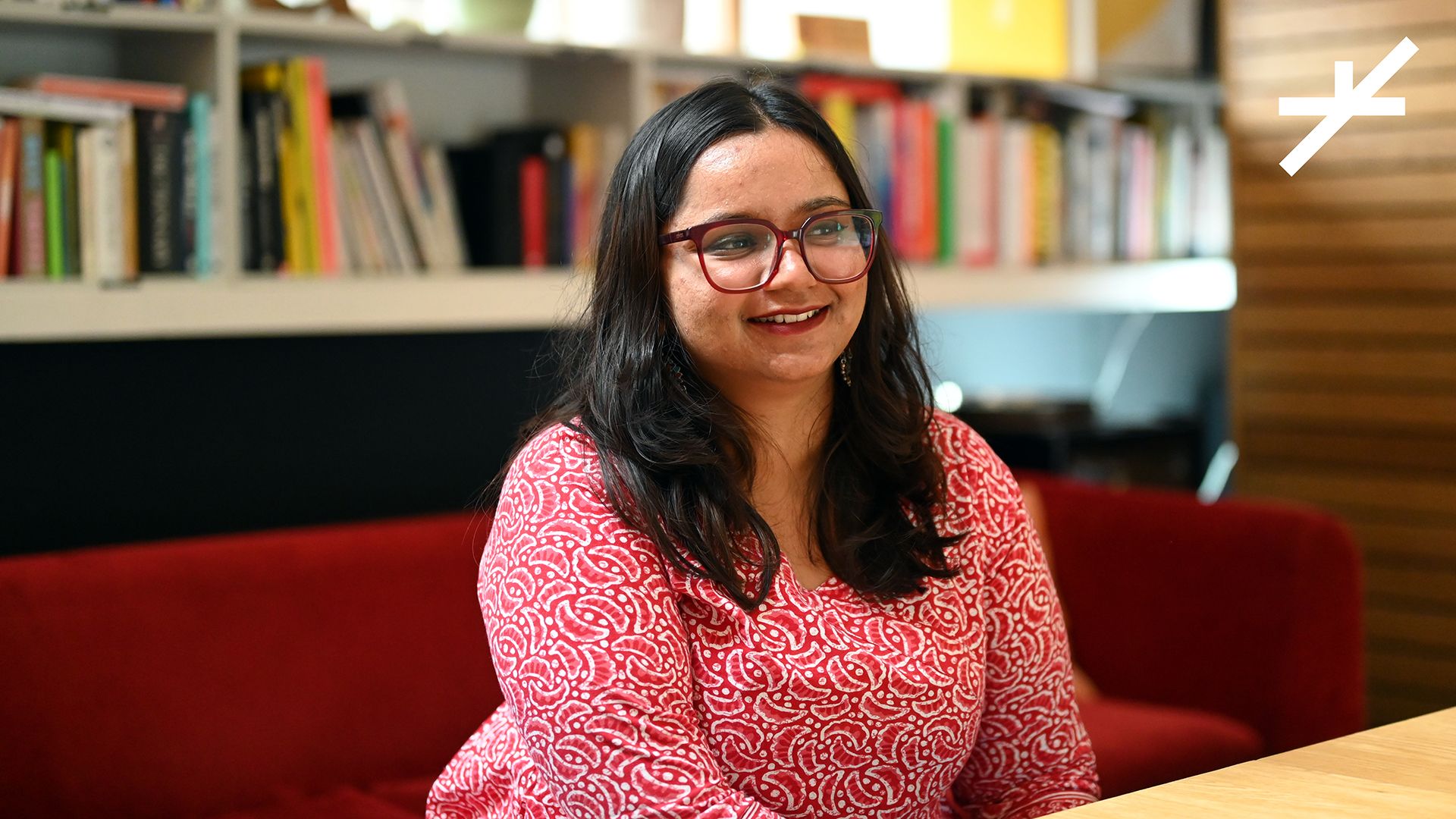 Aashini, our intern sits in front of a book shelf