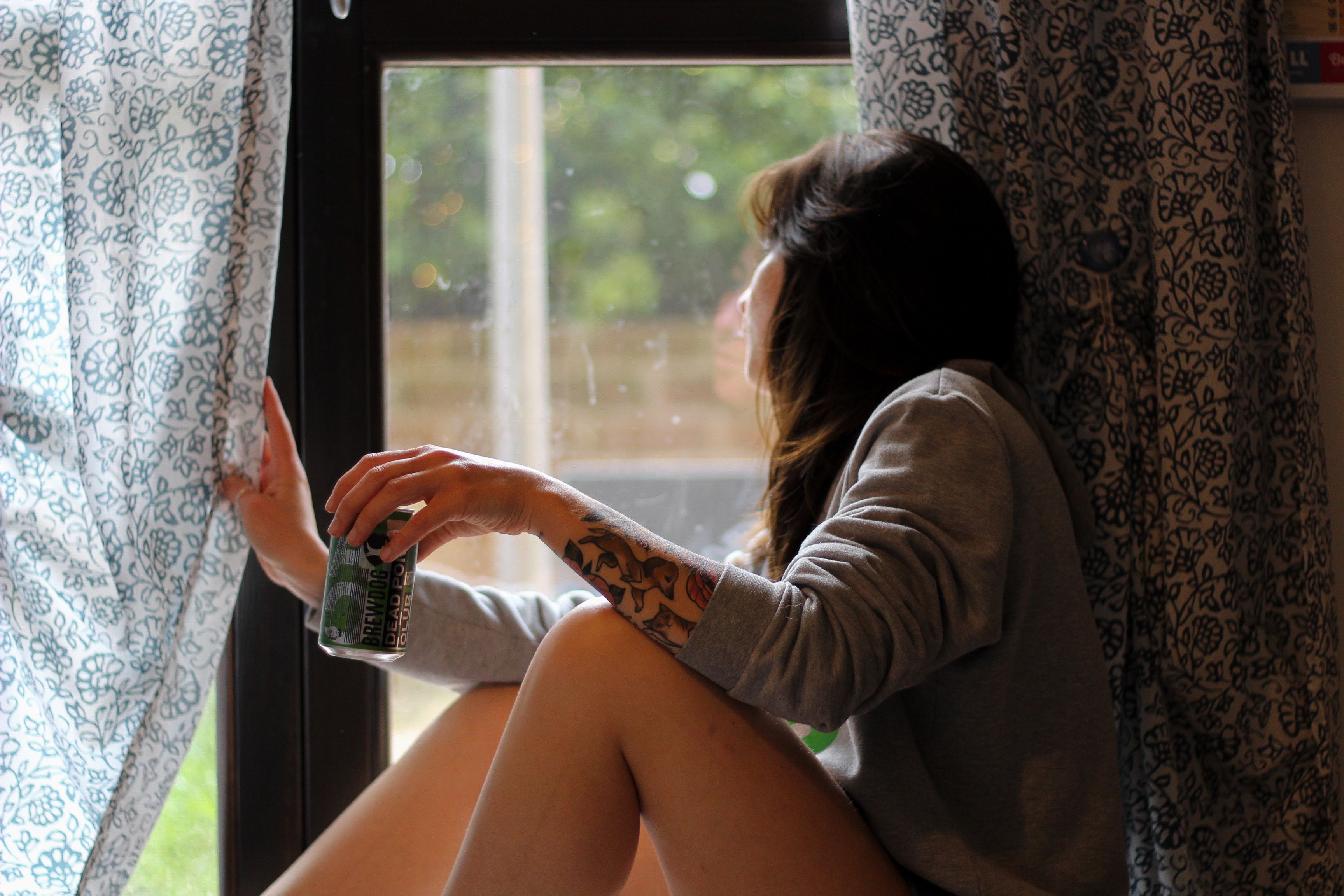 girl with drink looking through window