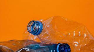 Crushed plastic bottles on an orange background