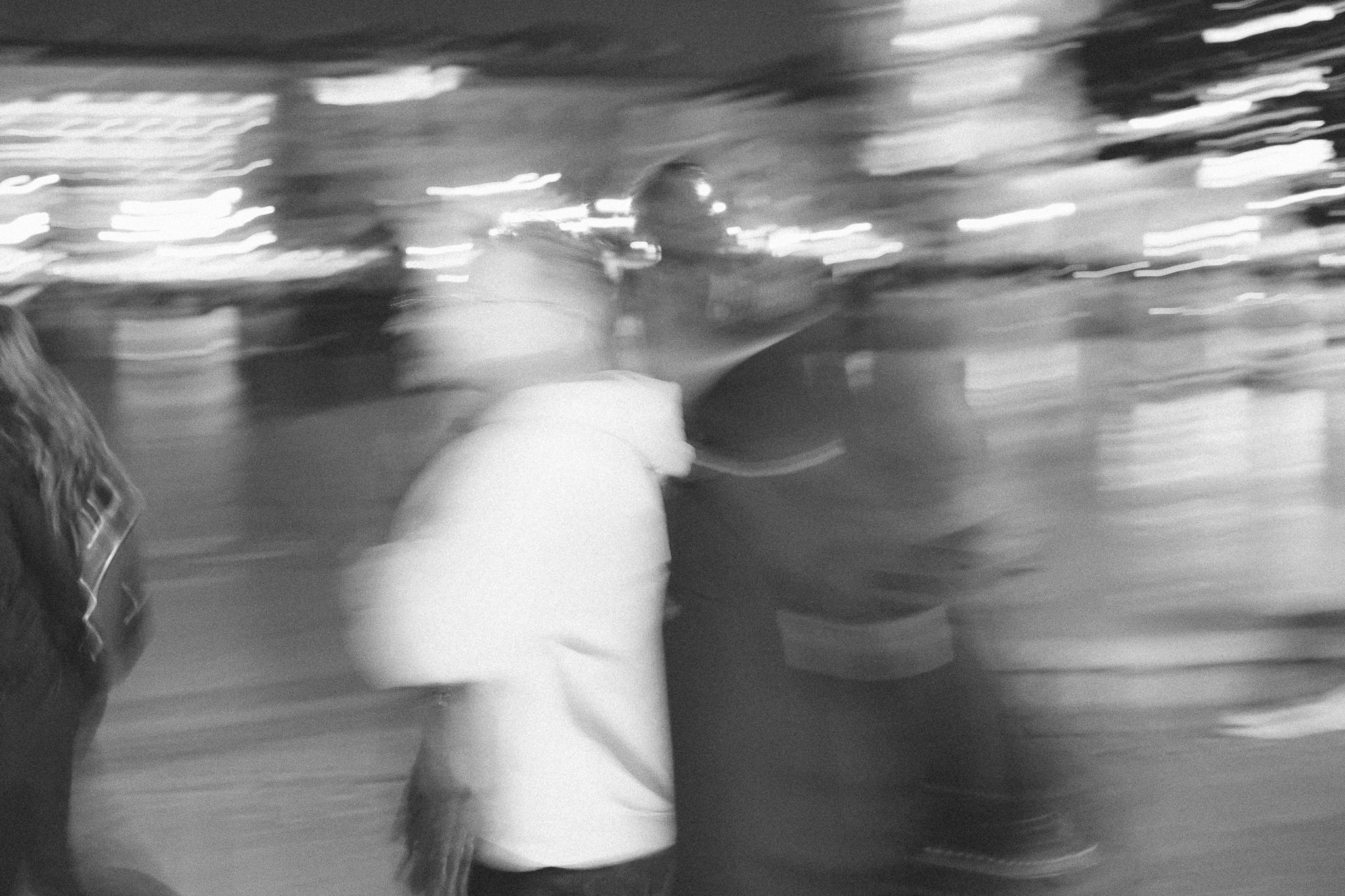 Blurry image of people on the street at night