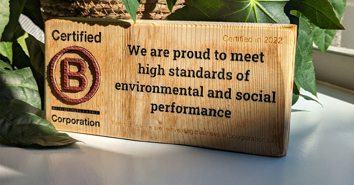 Wooden sign that reads Certified B Corporation. We are proud to meet high standards of environmental and social performance. Certified in 2022.