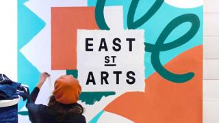 Woman in a hat working on an abstract painting