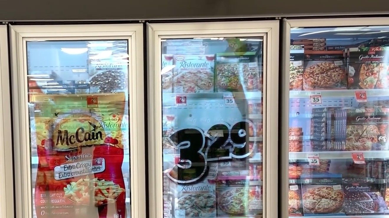 Promotion on transparent freezer doors in a grocery aisle
