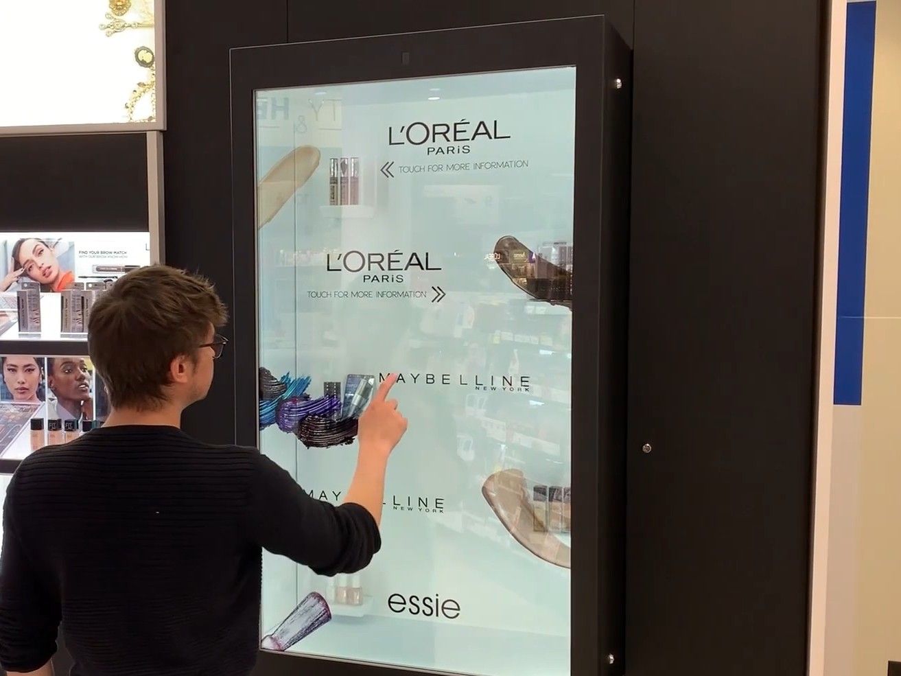 Wall-mounted transparent display in a drugstore beauty aisle