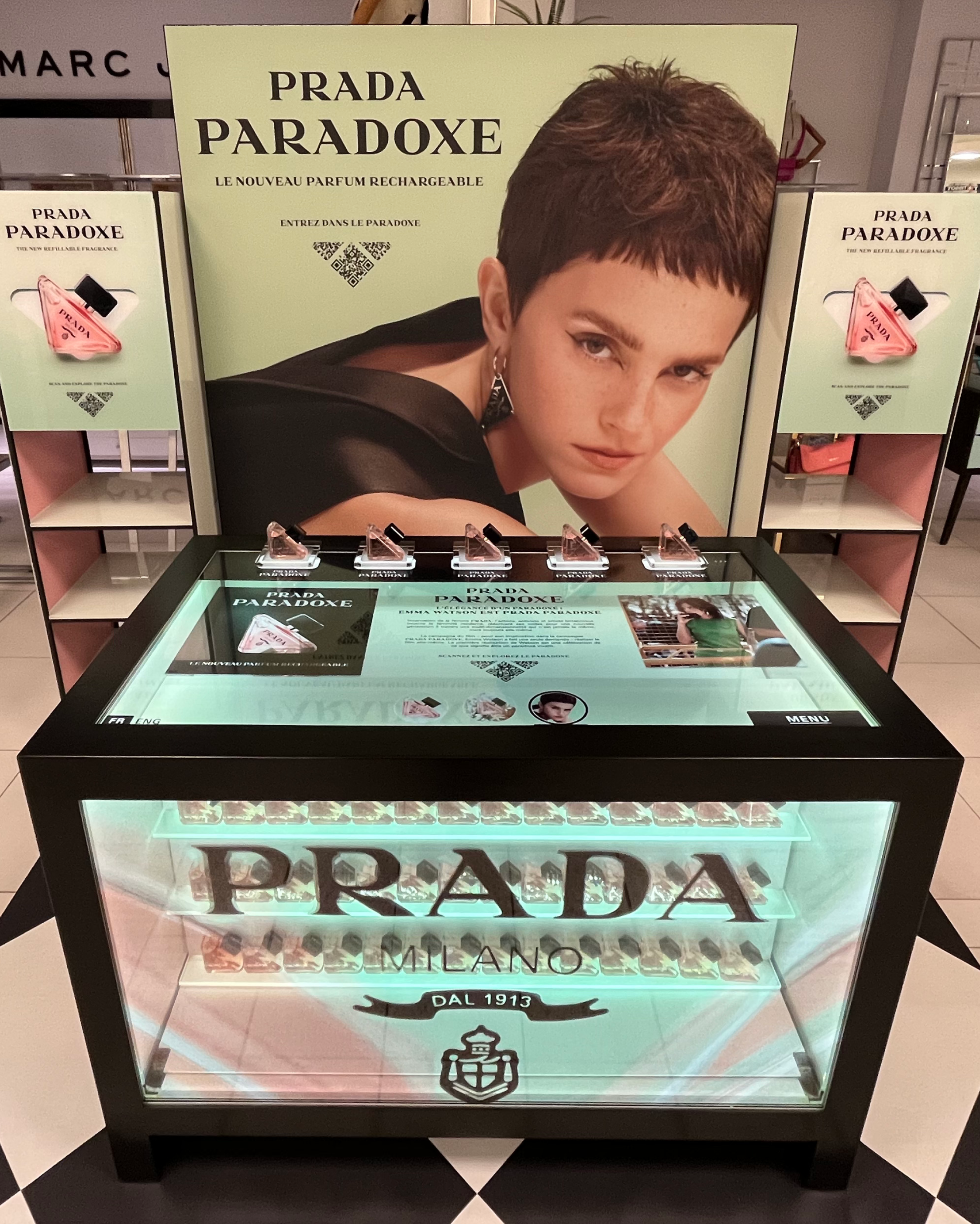 Transparent LCD counter in a department store, with brand content over the fragrance bottles