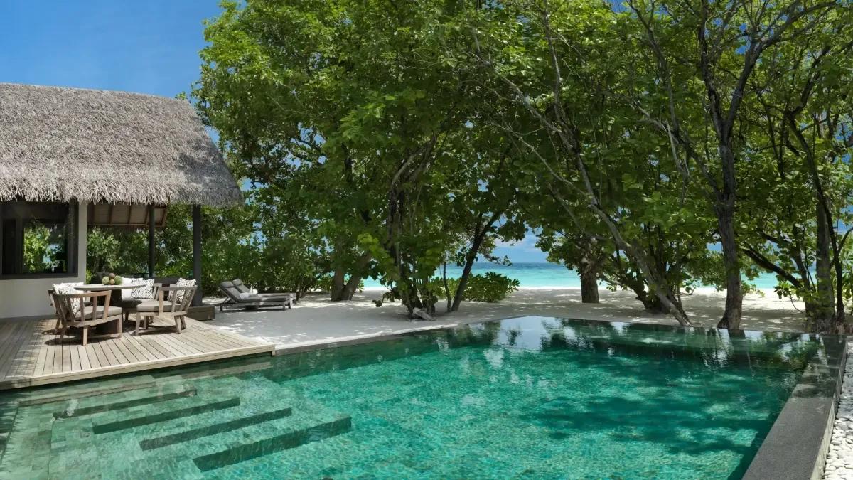 The private pool of a One Bedroom Deluxe Beach Pool Residence, glass doors open to the bedroom beyond