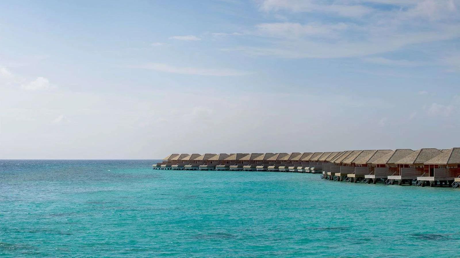 The row of overwater Ocean Villas at Hurawalhi stepping out across the turquoise lagoon