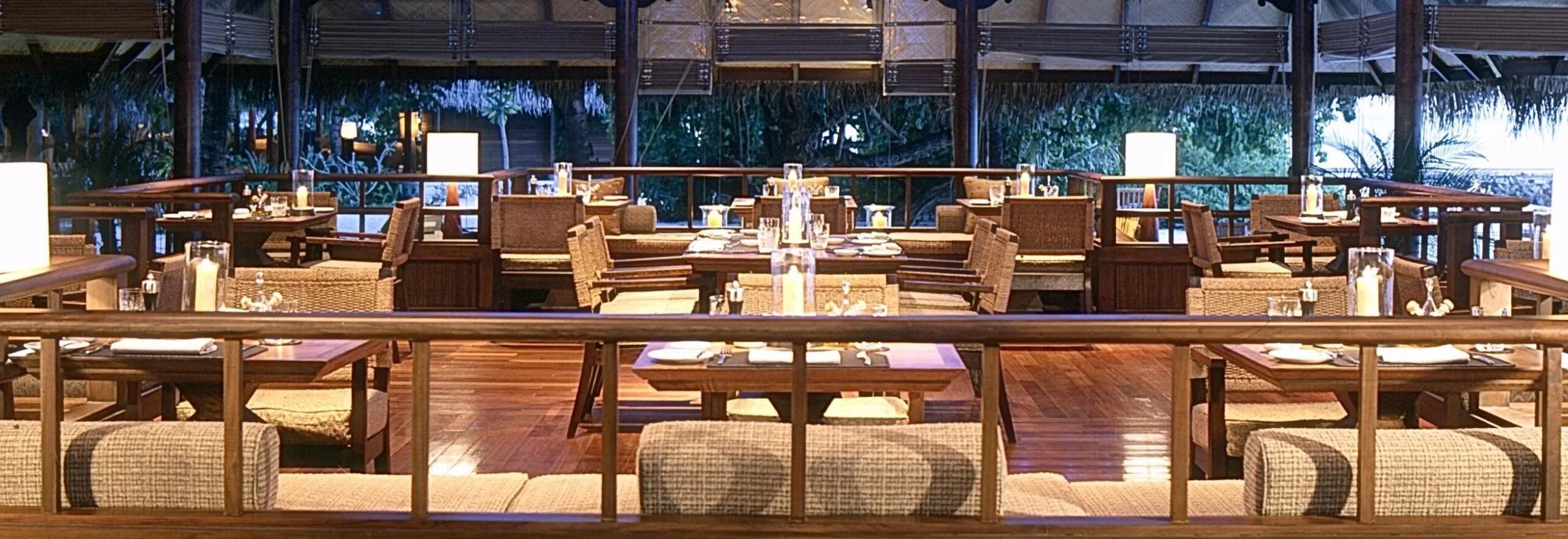 24 Degrees Restaurant's dining room in the evening, wicker chairs and candlelight around each table