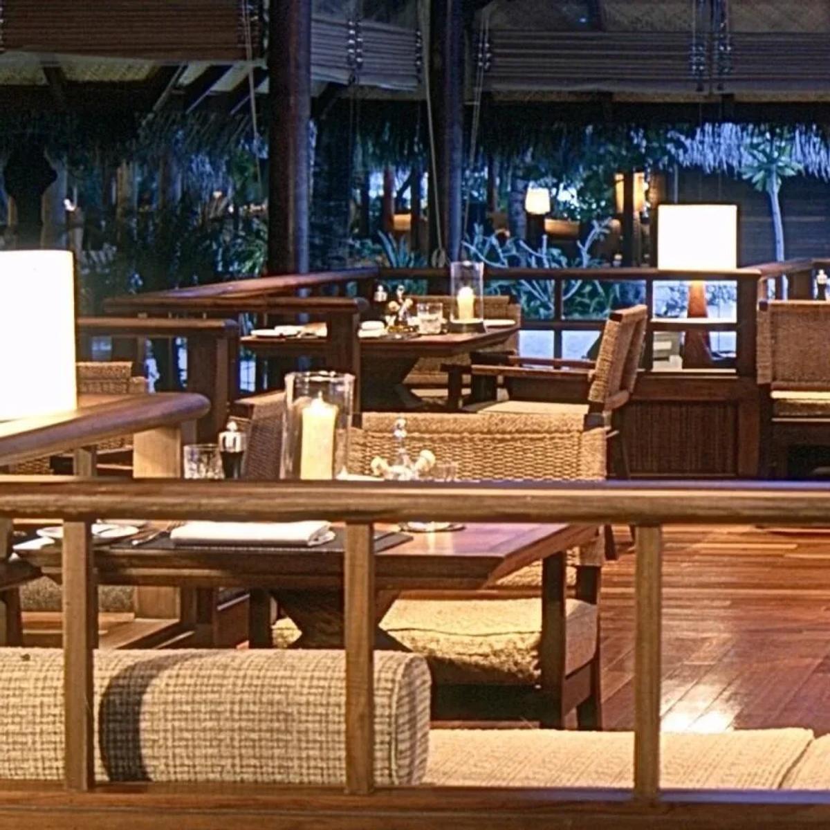 24 Degrees Restaurant's dining room in the evening, wicker chairs and candlelight around each table
