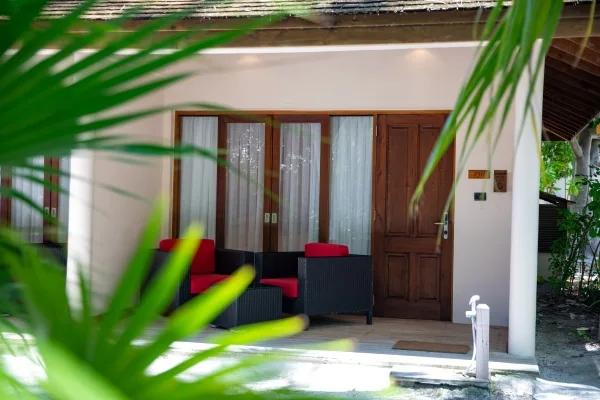 Tropical Villa bedroom interior, with a vaulted wood-beamed ceiling and garden-facing door