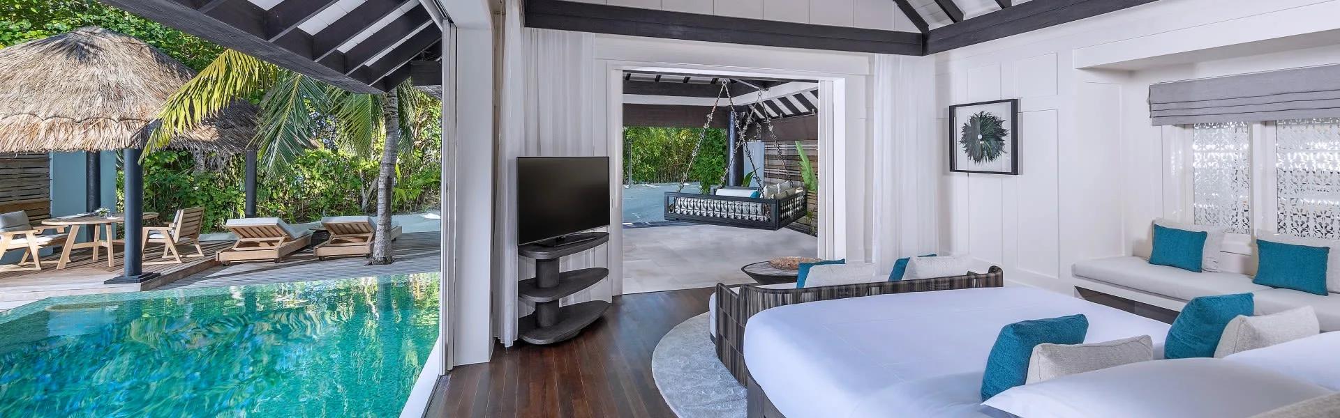 A Beach House with Pool's thatched dining pavilion beside the infinity pool, palms screening the deck