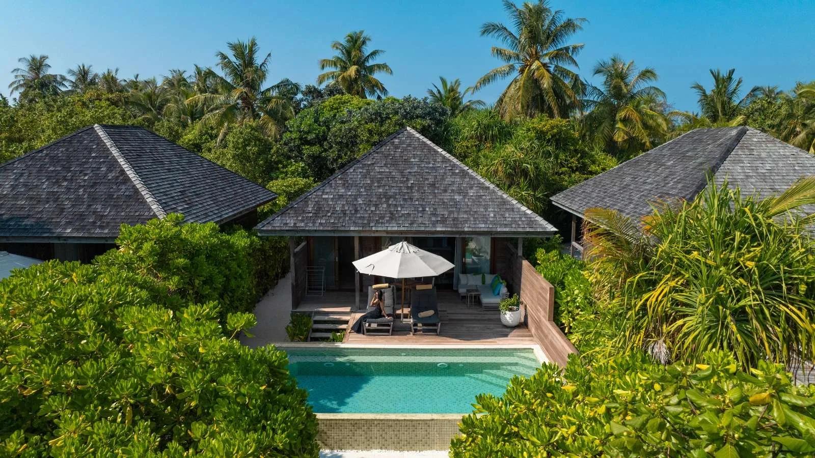 A Beach Pool Villa's shingled roof and private pool set among dense island greenery