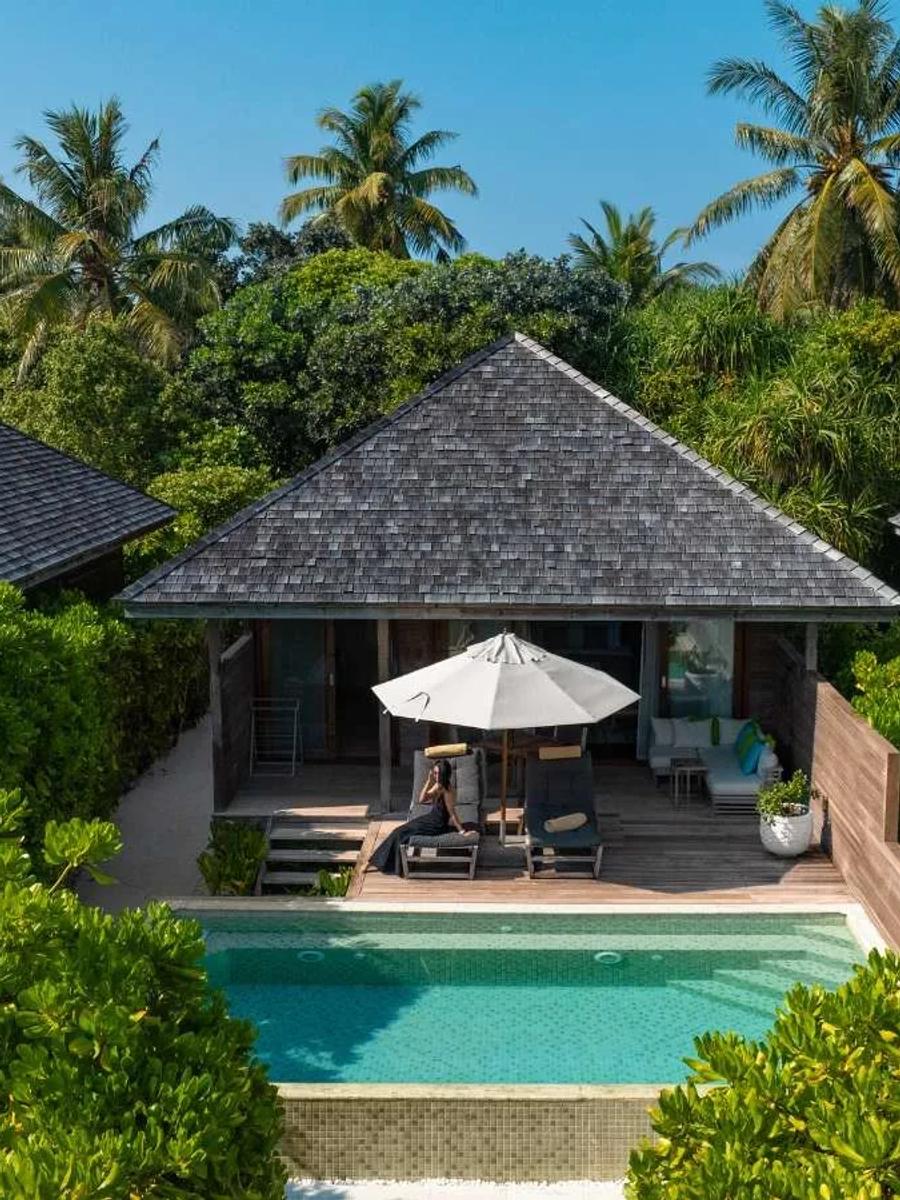 A Beach Pool Villa's shingled roof and private pool set among dense island greenery