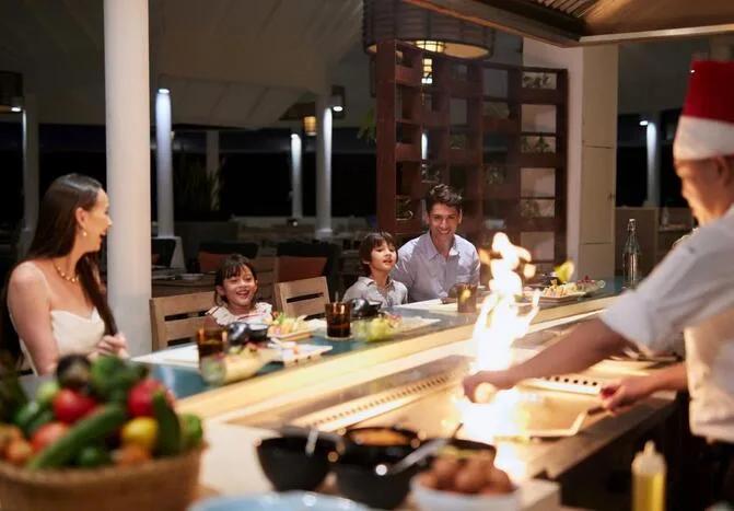 A family watching teppanyaki service at Reef, the resort's main buffet restaurant