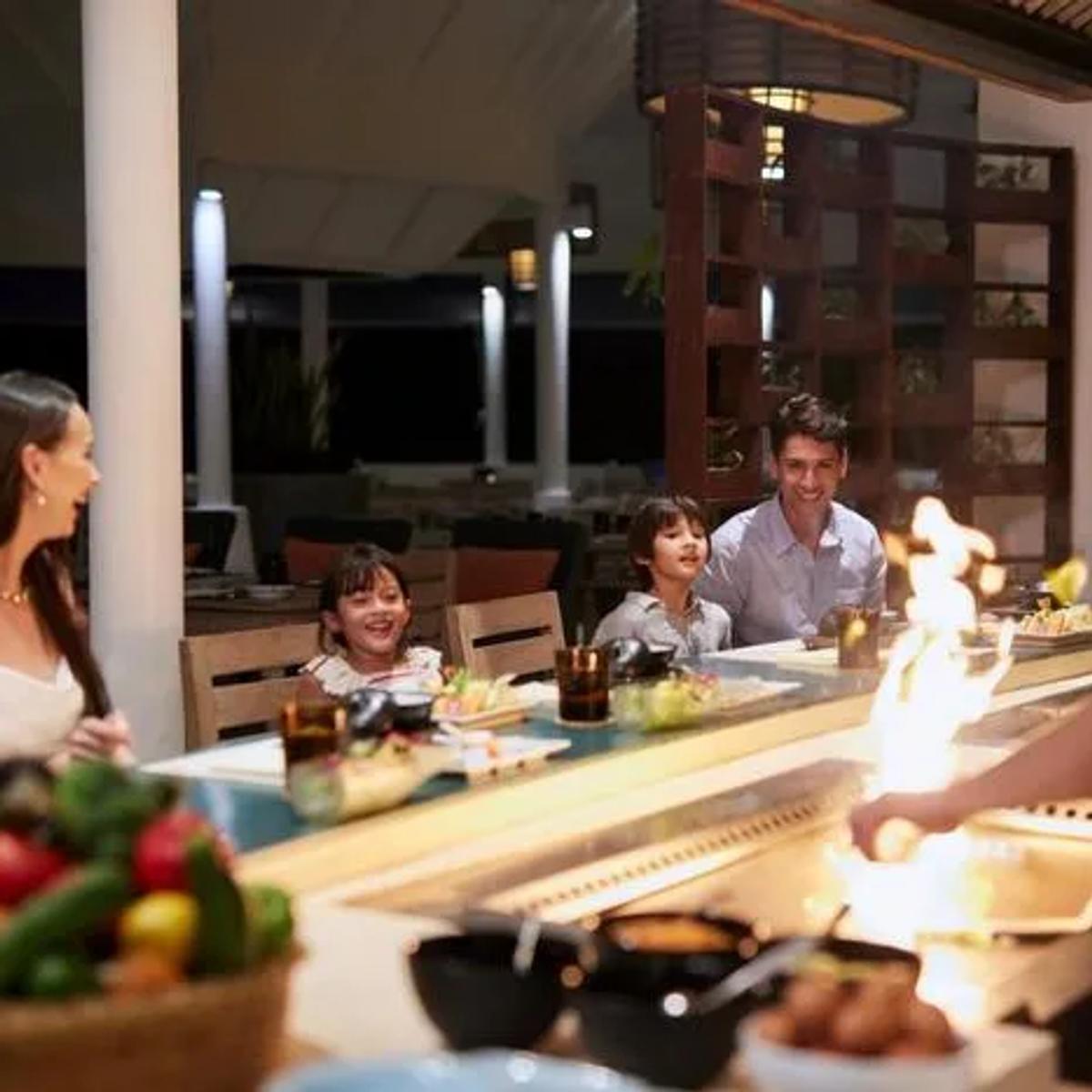 A family watching teppanyaki service at Reef, the resort's main buffet restaurant