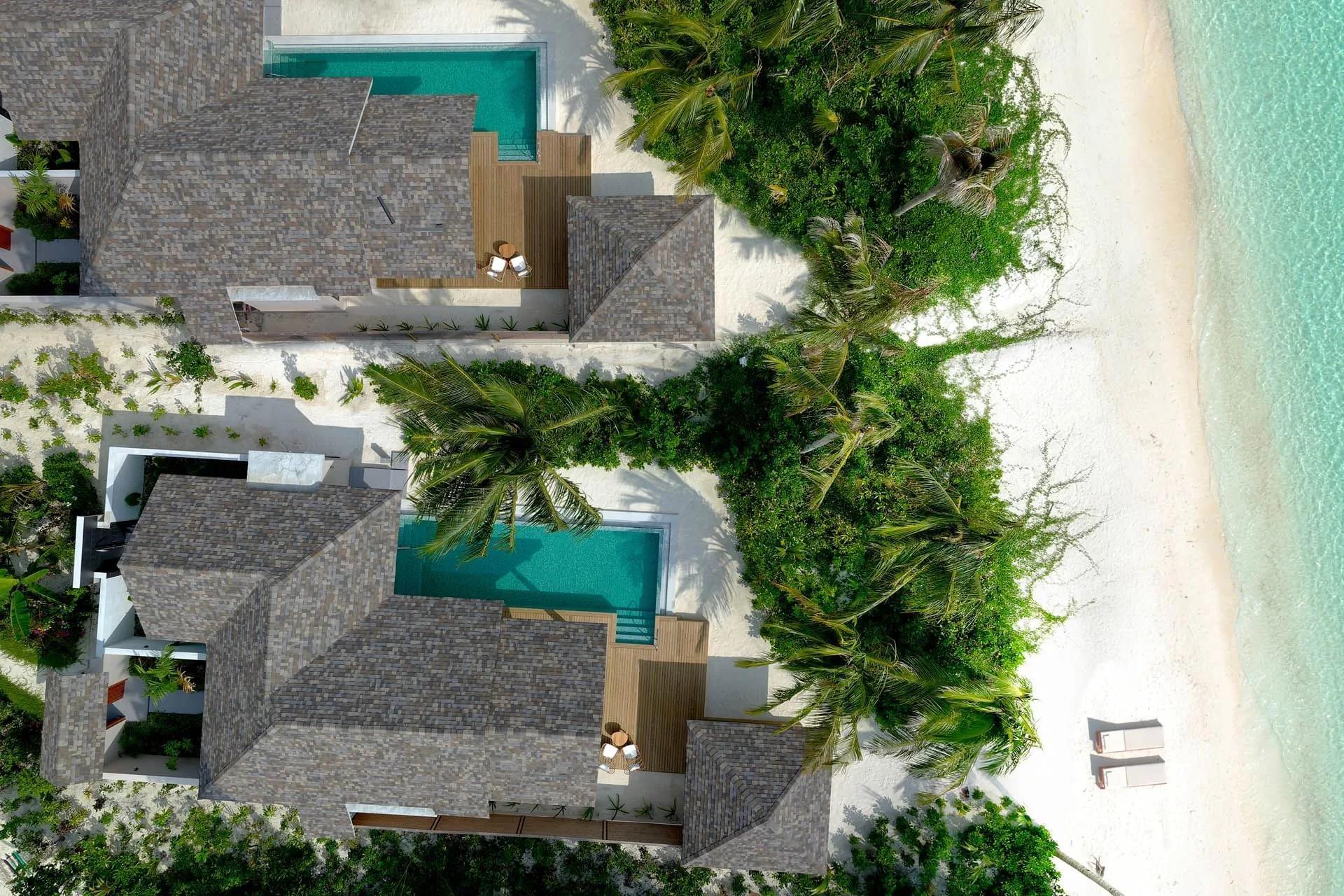 A Deluxe Beach Pool Villa seen from above, its private pool set among dense island greenery