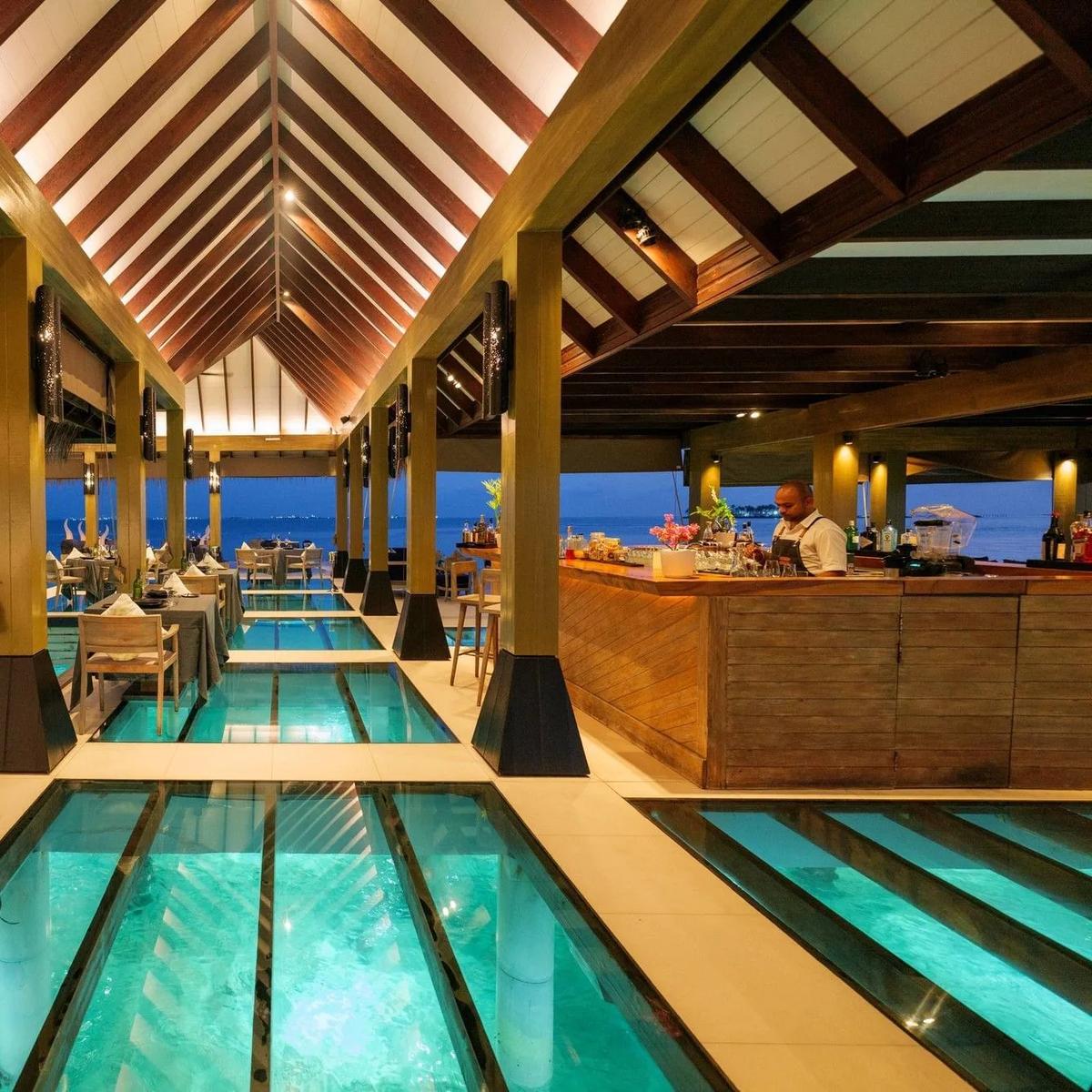 Firedoor, the resort's overwater fine-dining restaurant, reached by a wooden walkway