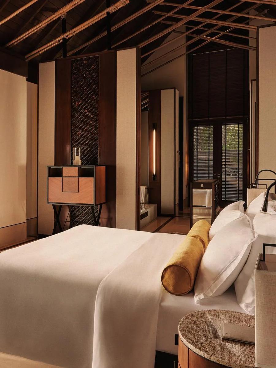 The bedroom of a Beach Villa with Pool at One&Only Reethi Rah, opening onto its private pool with the beach beyond