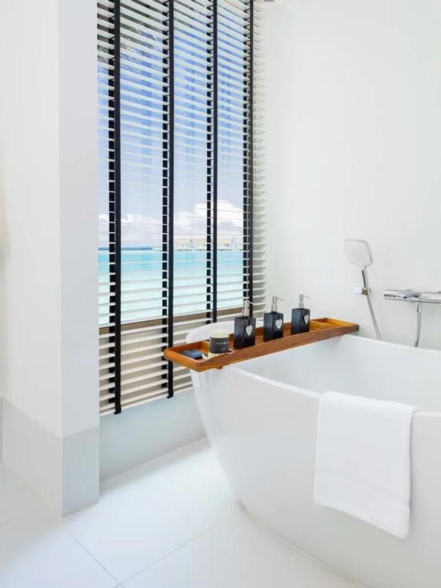 A Platinum-category overwater villa's interior, opening onto the deck above the lagoon
