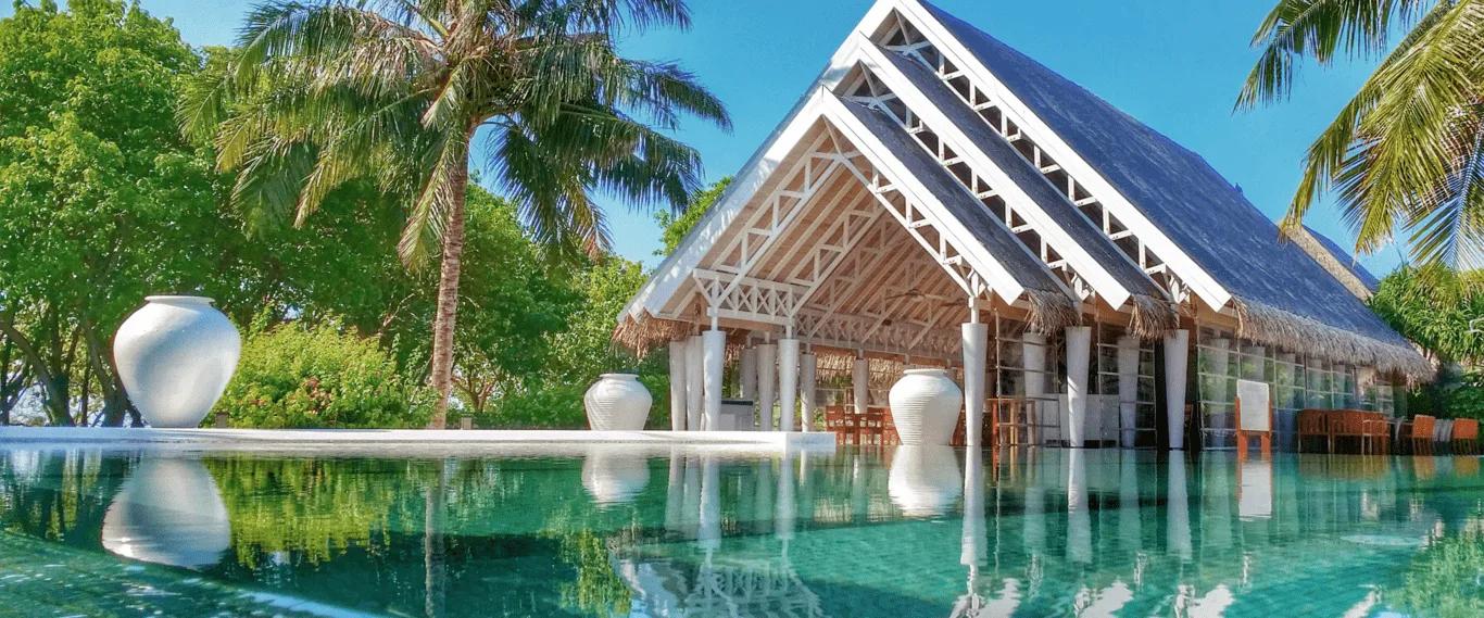 Senses Restaurant's pool-facing pavilion, framed by tall white urns and palm trees