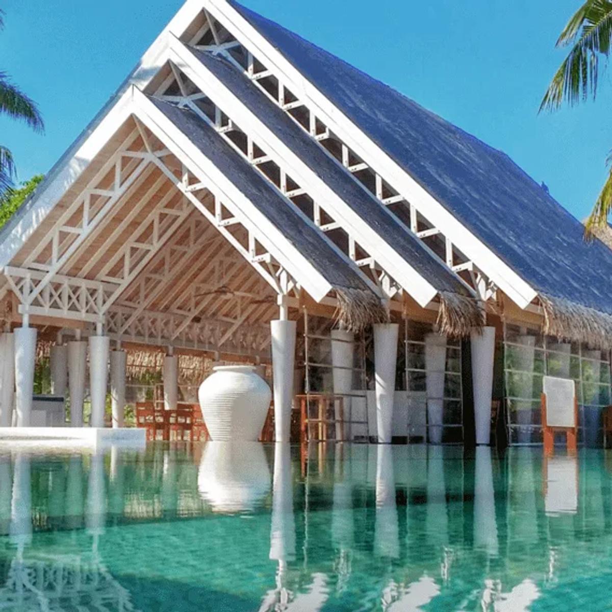 Senses Restaurant's pool-facing pavilion, framed by tall white urns and palm trees