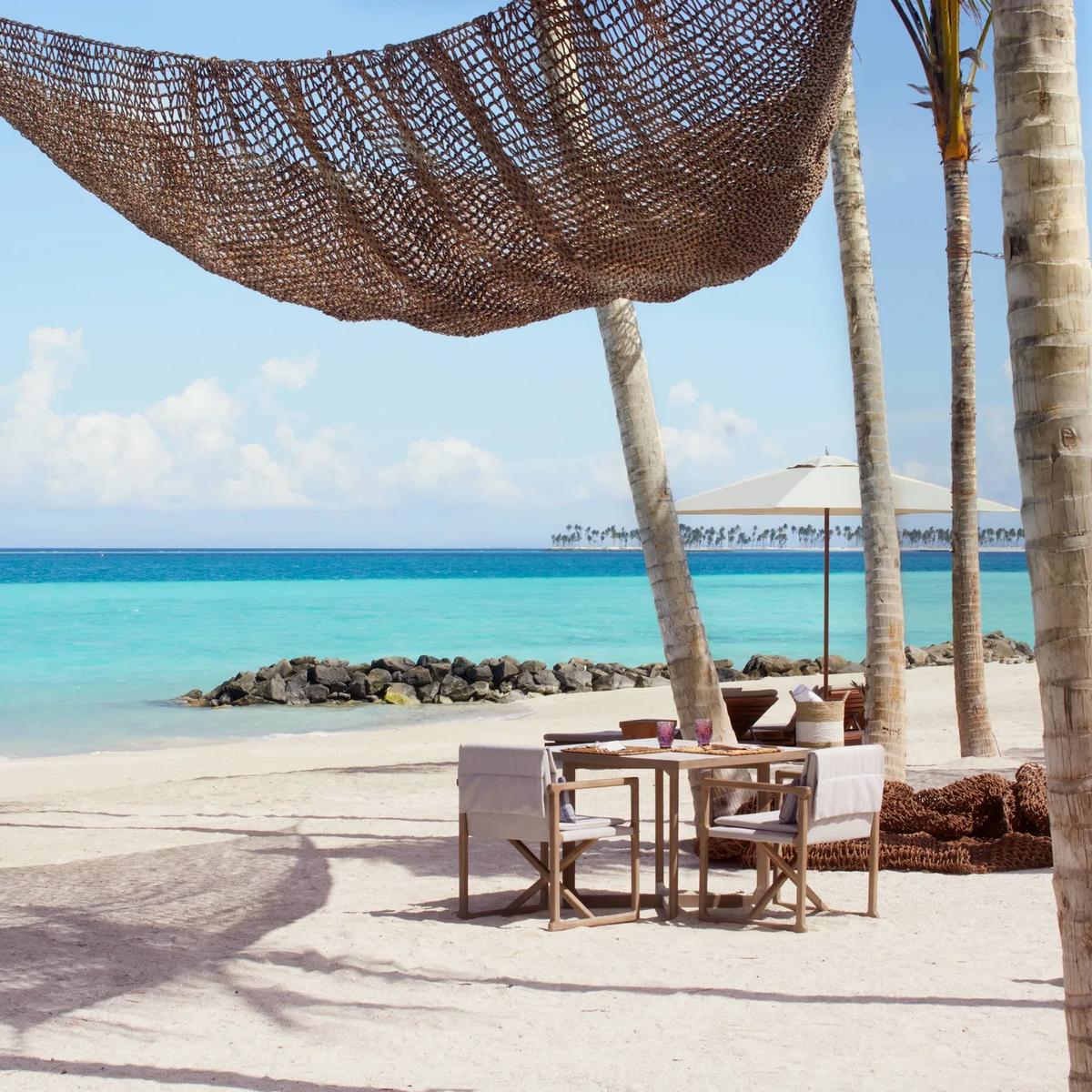 Beach Shack's dining tables strung with woven hammocks over the sand