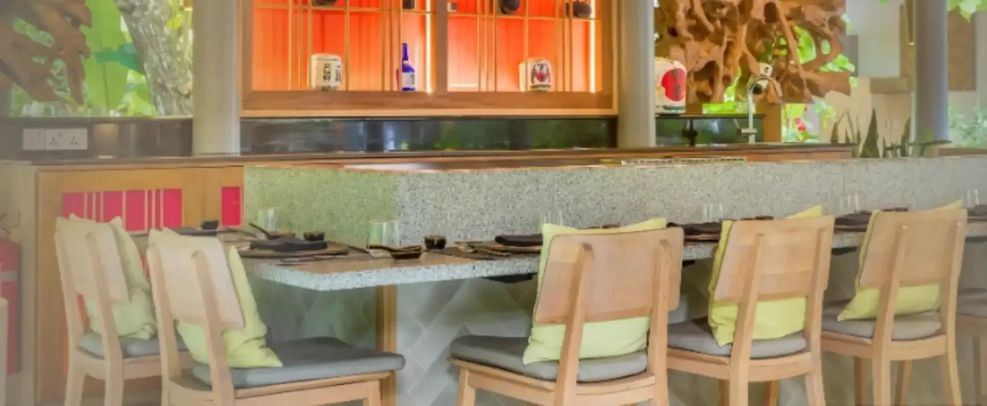 Anguru's teppanyaki counter and seating, an open grill station facing rows of wooden bar stools