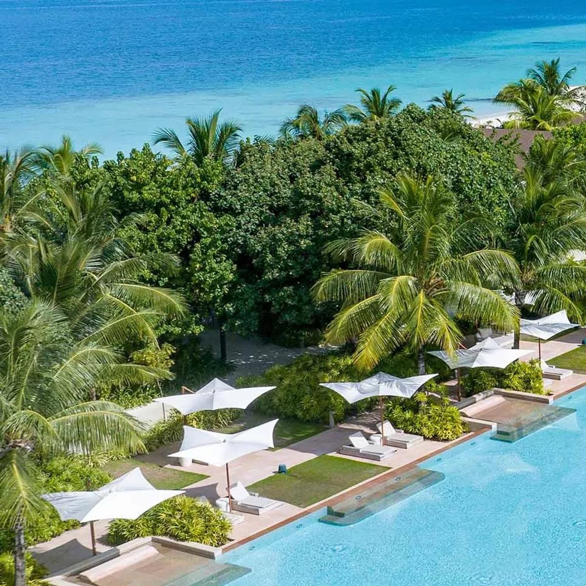 An aerial view of Kuda Villingili Resort Maldives' 150-metre pool, the largest swimming pool in the Maldives, framed by the island and lagoon