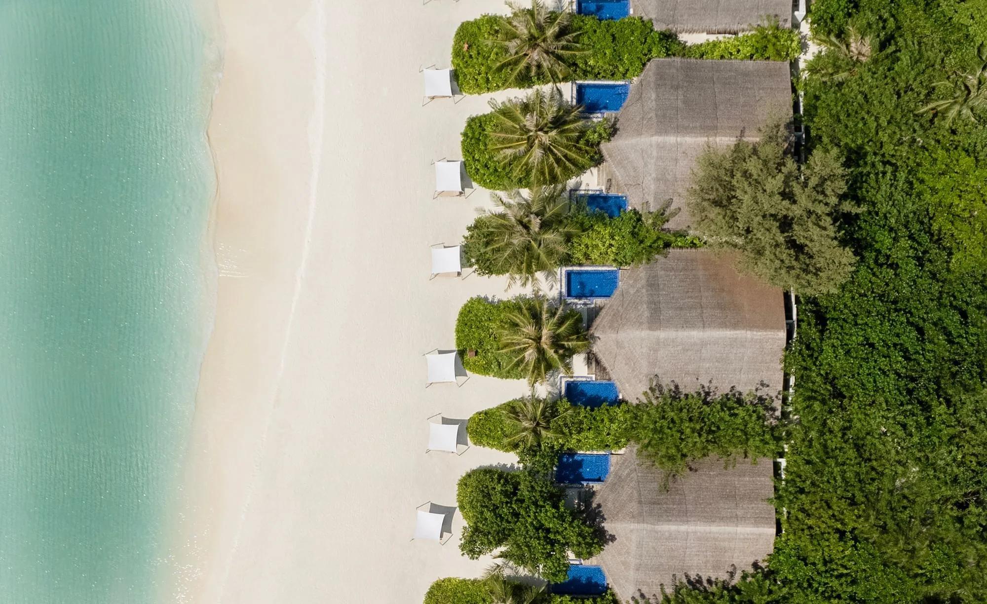 An aerial view of the whole island at Grand Park Kodhipparu, reef and lagoon surrounding the resort