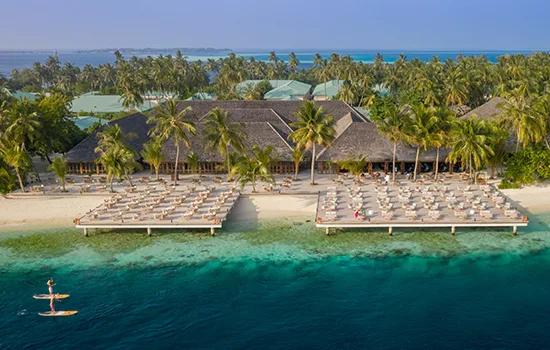 Aerial view of Vilamendhoo's overwater sun decks, beach and sports courts among the palms