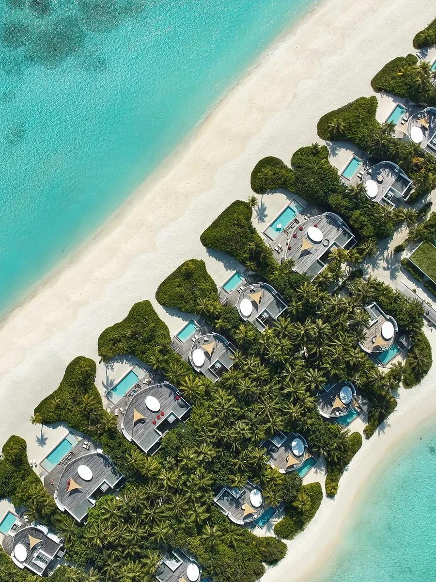 Aerial view of the beachfront villa row at Jumeirah Olhahali, reef visible in the lagoon beyond