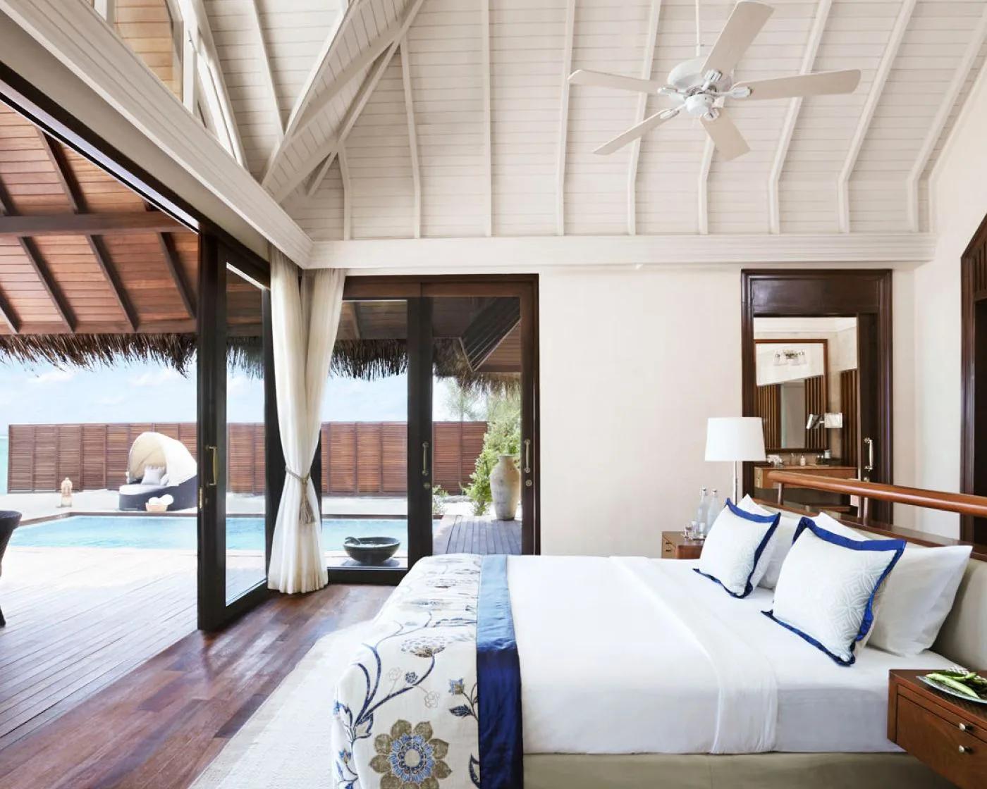 A Sunrise Oceanfront Villa with Pool's bedroom, glass doors folded open onto its private pool and daybed