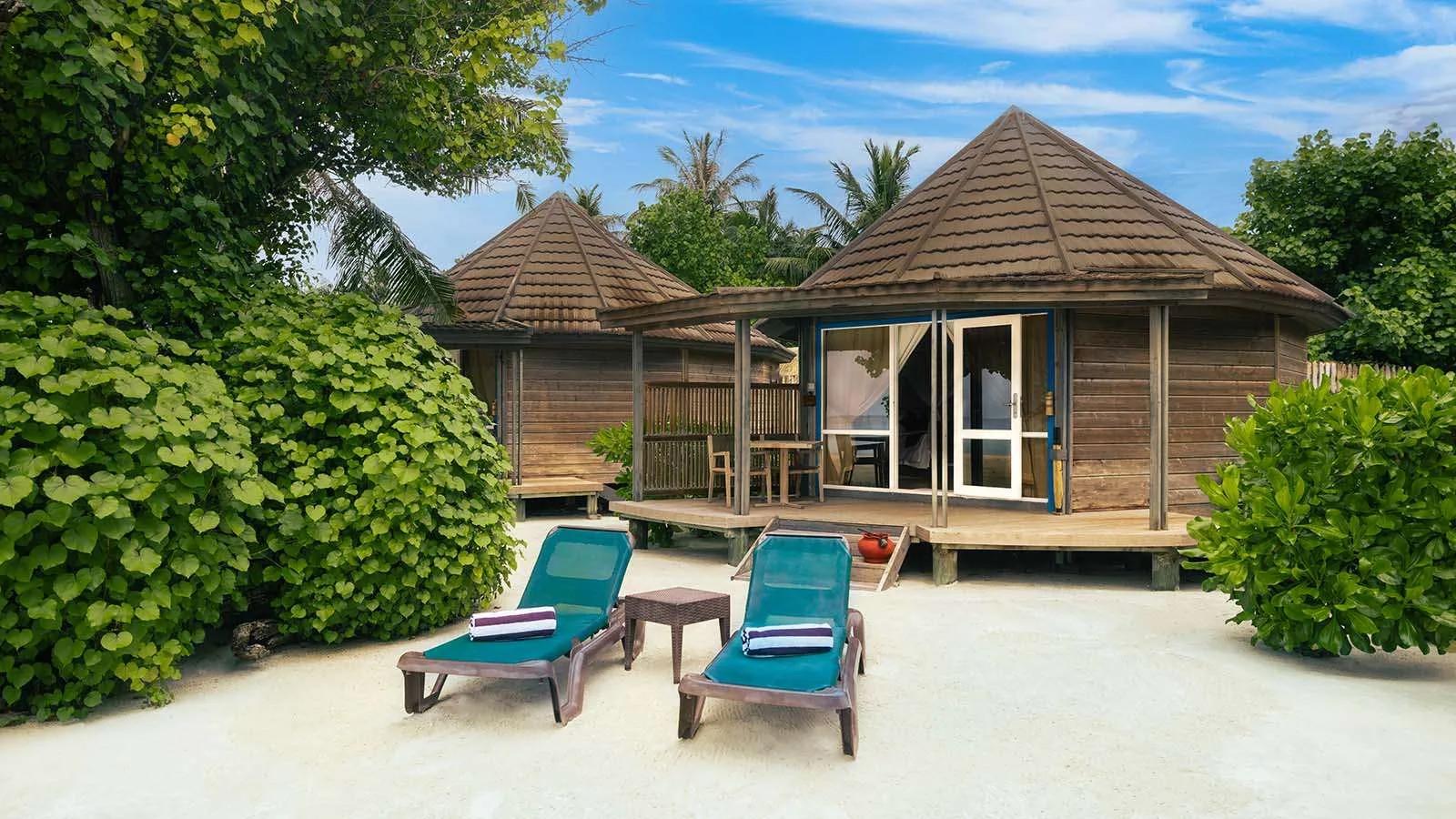 O Jacuzzi Beach Villa exterior, a round wood-panelled villa with blue-trimmed doors