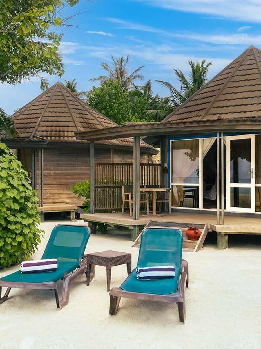 O Jacuzzi Beach Villa exterior, a round wood-panelled villa with blue-trimmed doors
