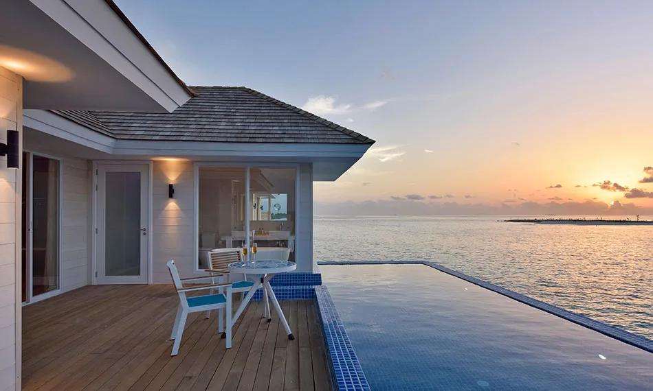 The Sunset Aqua Pool Suite's private infinity pool and deck at sunset, built out over the lagoon