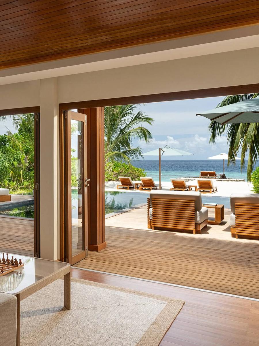 The Two-Bedroom Beach House's living room opening onto its private pool and the beach