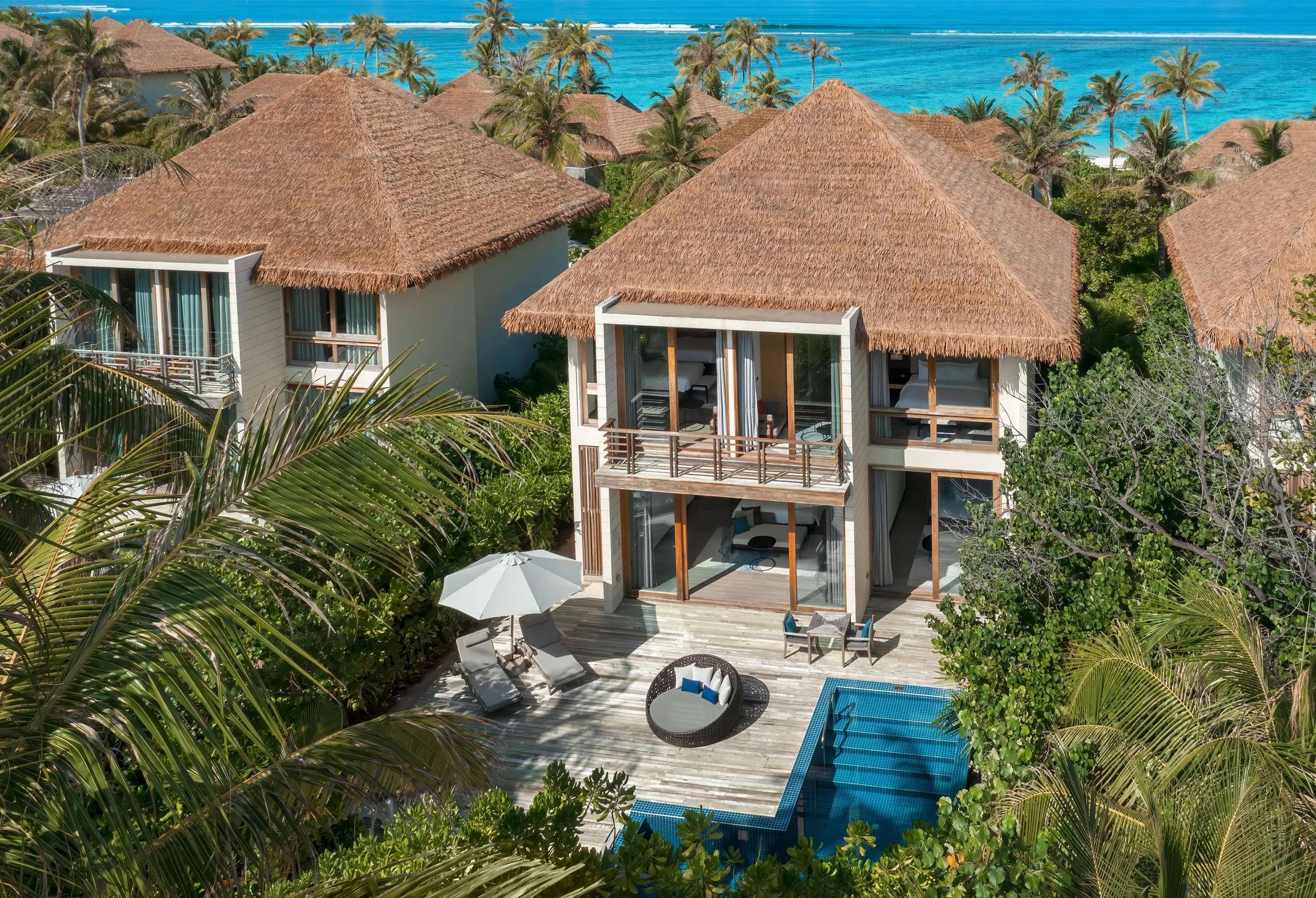A beachfront villa's private plunge pool and sun deck at Radisson Blu Resort Maldives, set back from the sand beneath tall palms