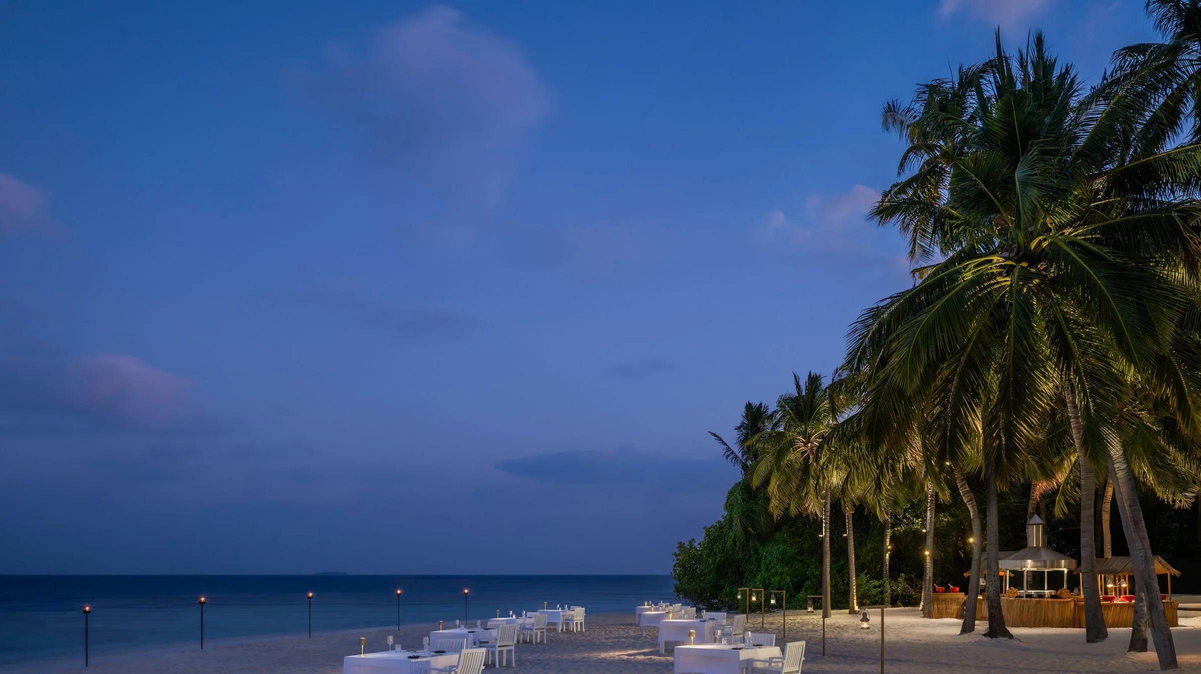 Torch-lit tables at The Firepit, Halcyon's open-flame beach grill