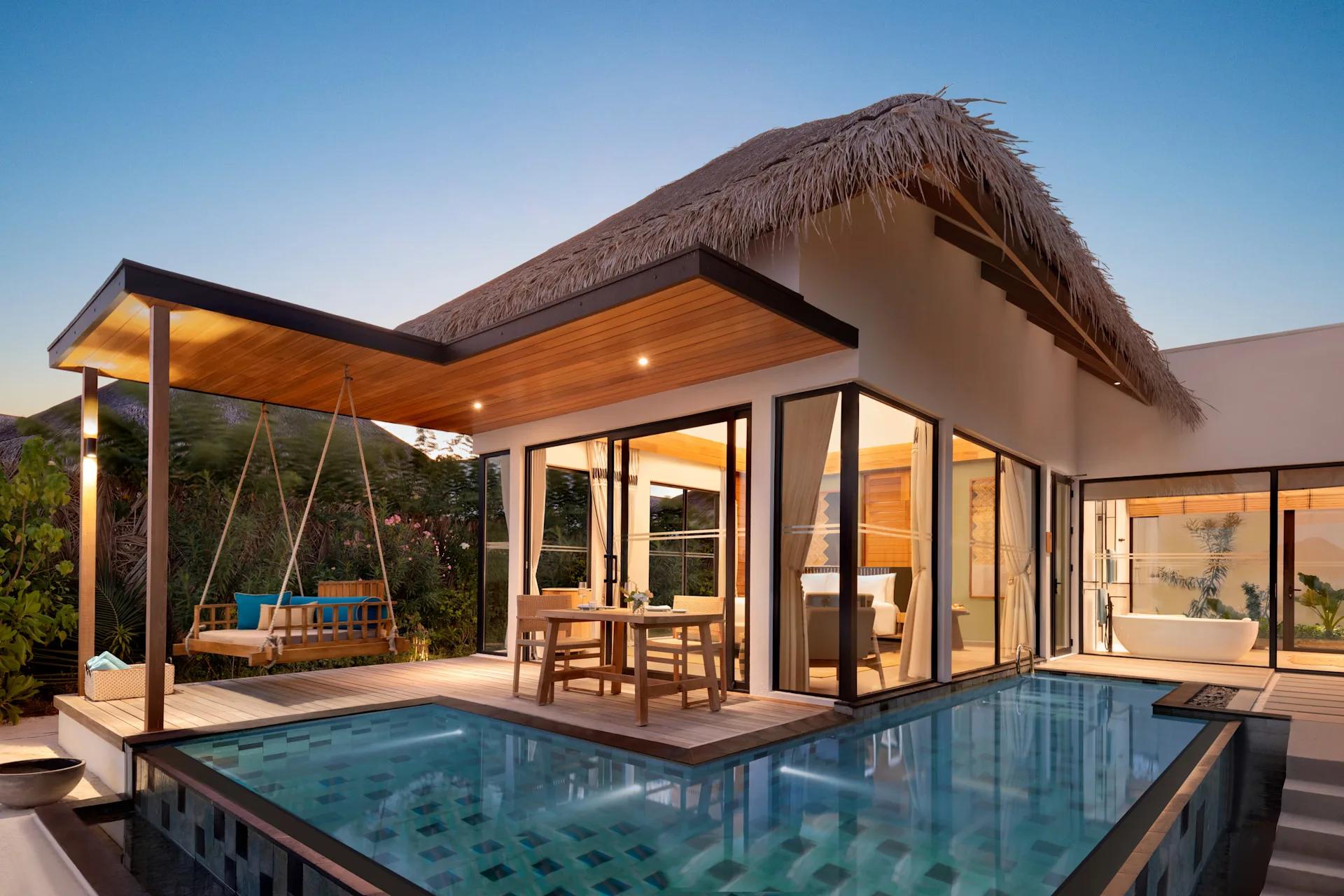 The exterior of a One Bedroom Beach Pool Villa, set among palms with its own private pool
