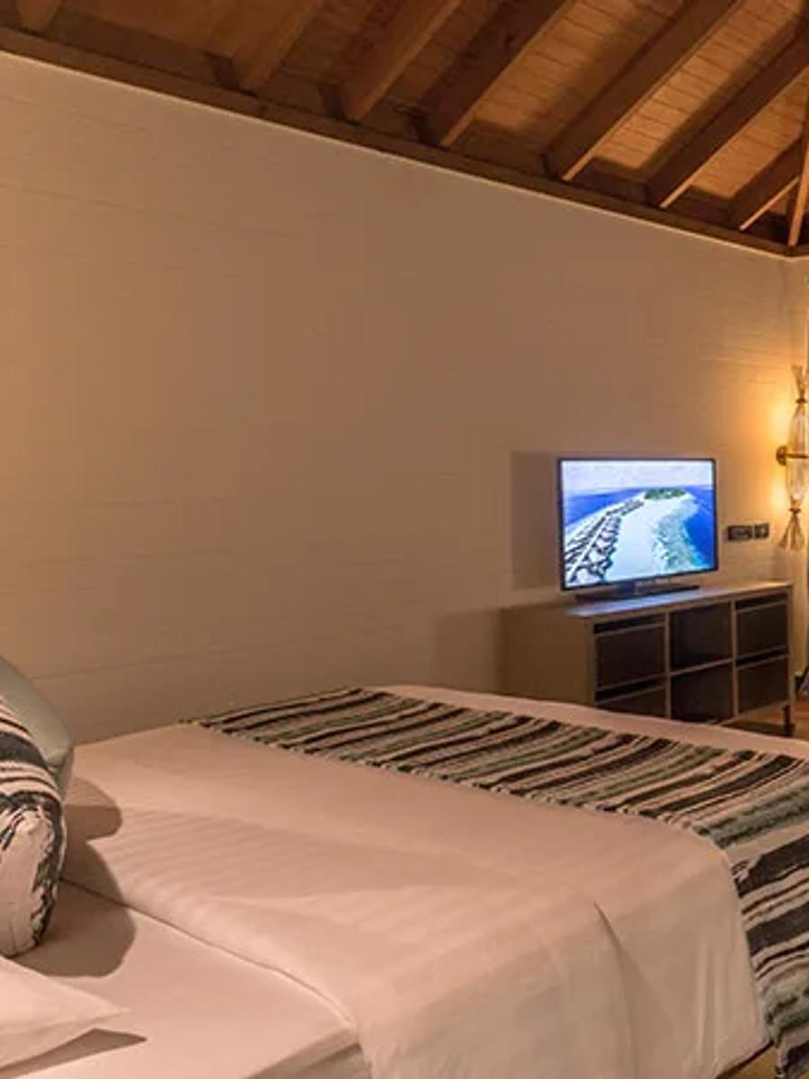 Romantic Ocean Villa interior at dusk, with the private deck opening straight onto the lagoon