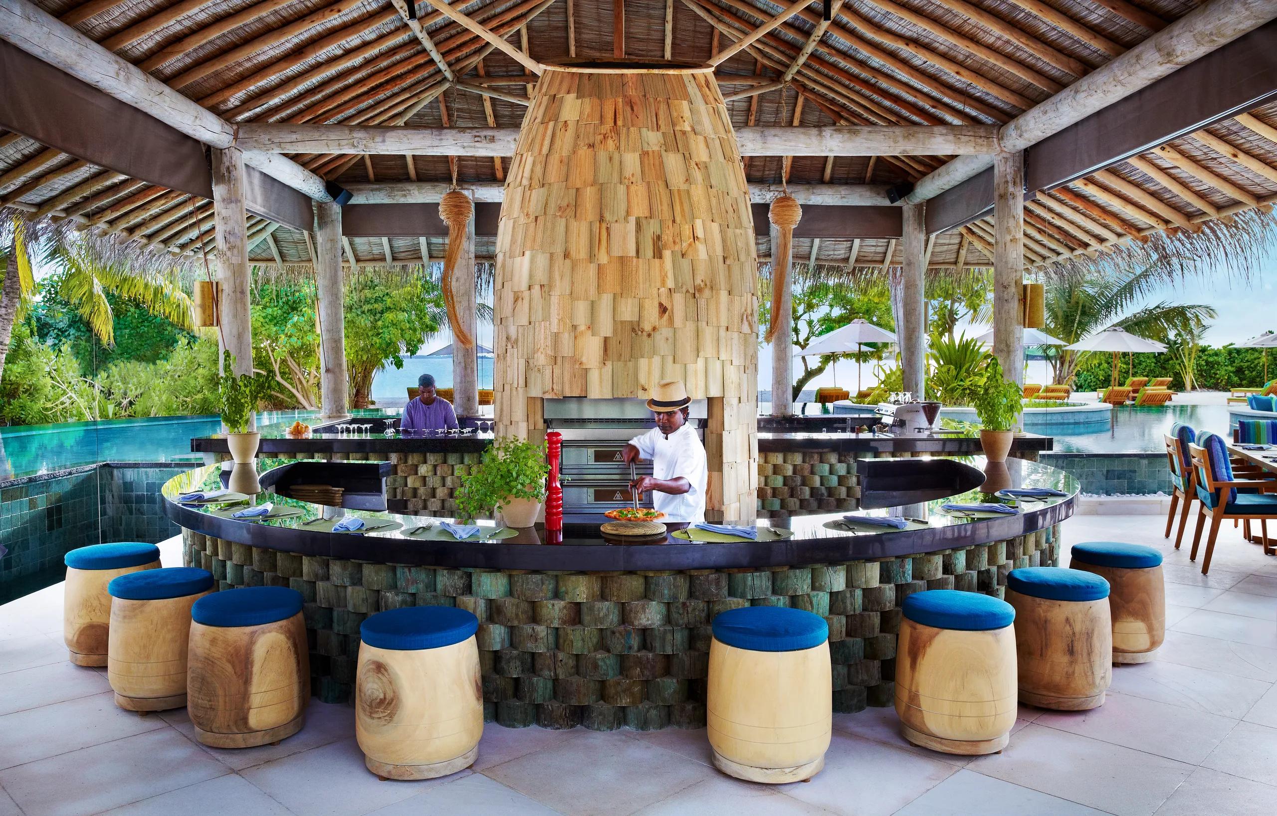 A double-height timber-framed dining pavilion roof with hanging light fixtures