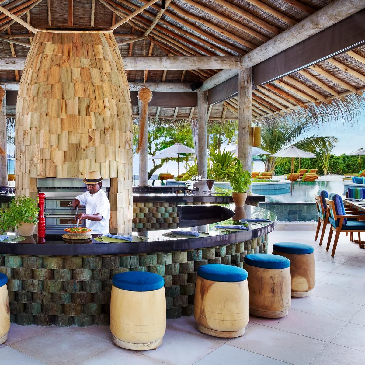 A double-height timber-framed dining pavilion roof with hanging light fixtures