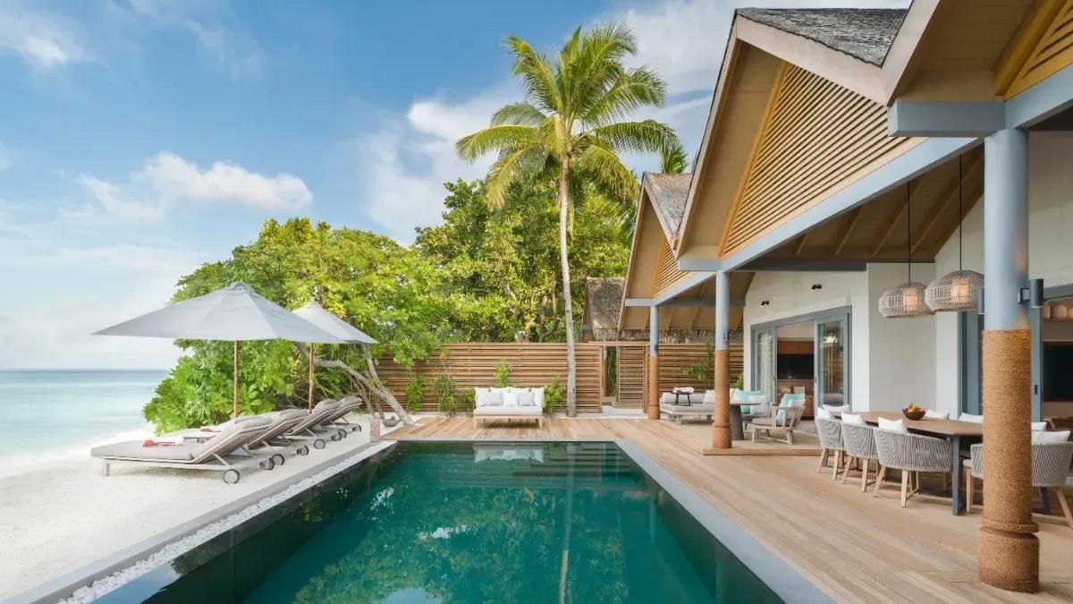 Exterior of the Four Bedroom Beach Pool Residence by day, its pool and dining deck facing the beach and lagoon