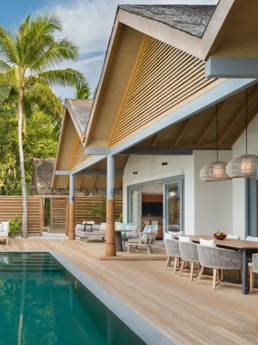 Exterior of the Four Bedroom Beach Pool Residence by day, its pool and dining deck facing the beach and lagoon