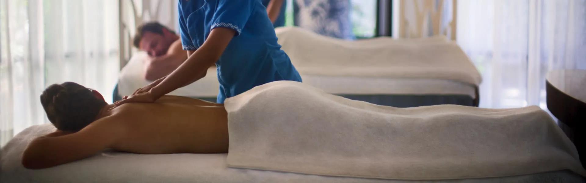 A guest receiving a massage at Balance Wellness by Anantara, with a second guest treated behind