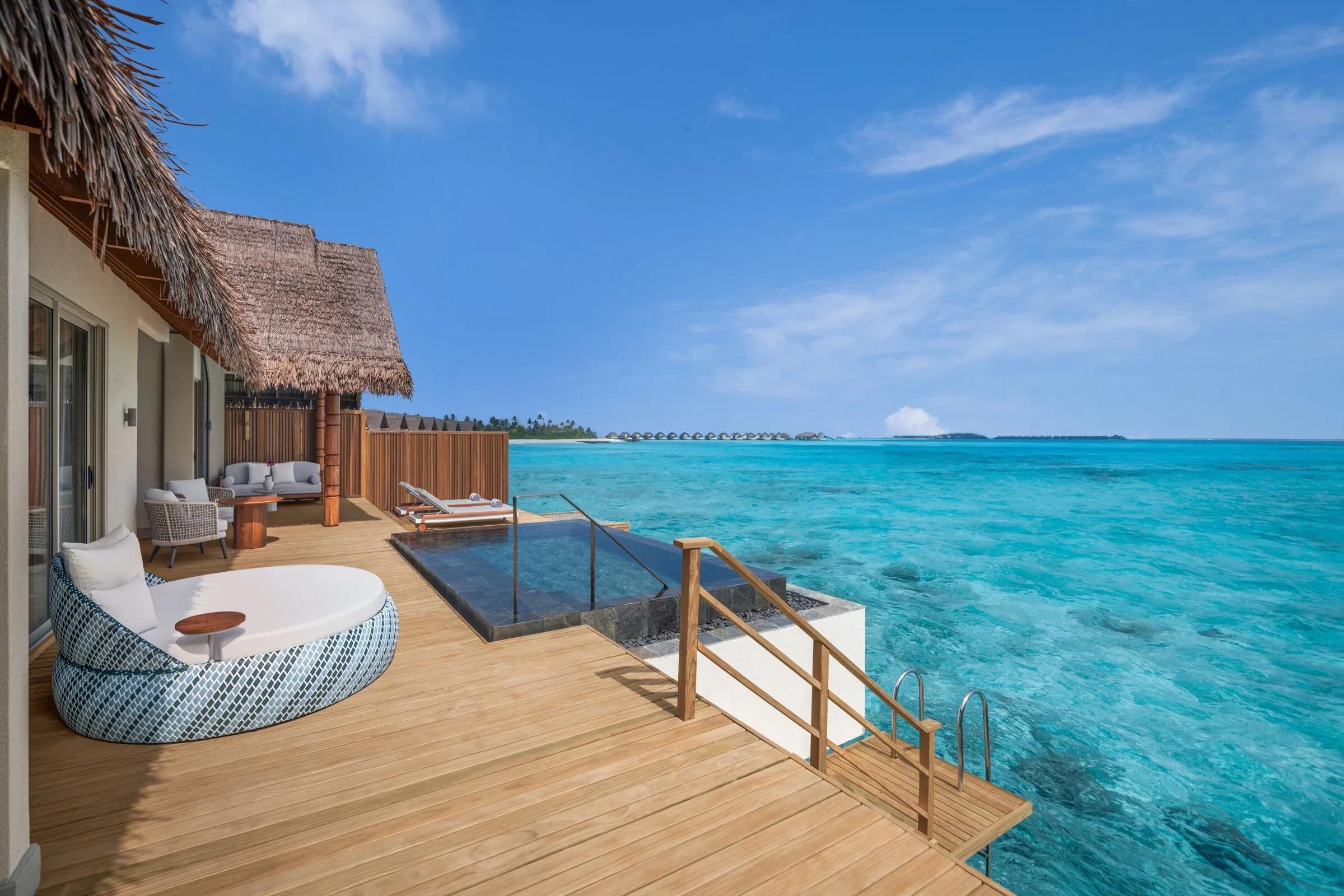 The pool deck of an Overwater Pool Villa, steps leading down into the lagoon