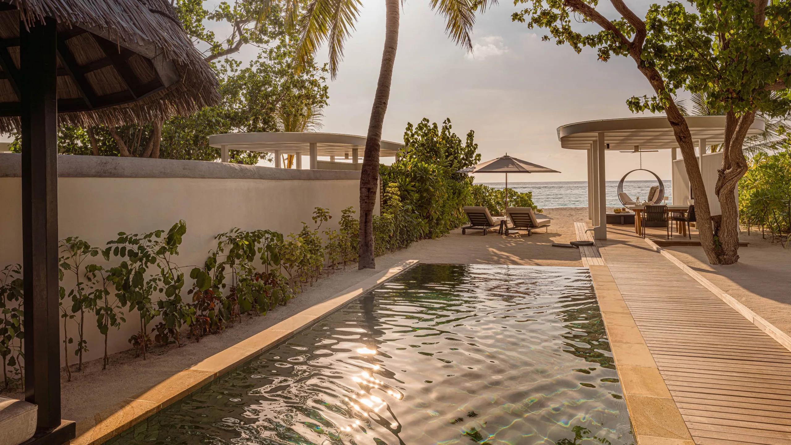 A Sunset Beach Villa's pool and boardwalk leading to the beach at dusk