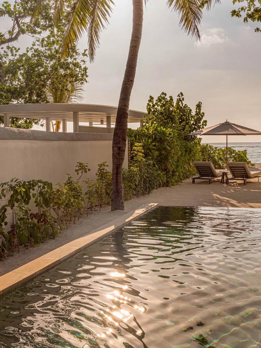 A Sunset Beach Villa's pool and boardwalk leading to the beach at dusk
