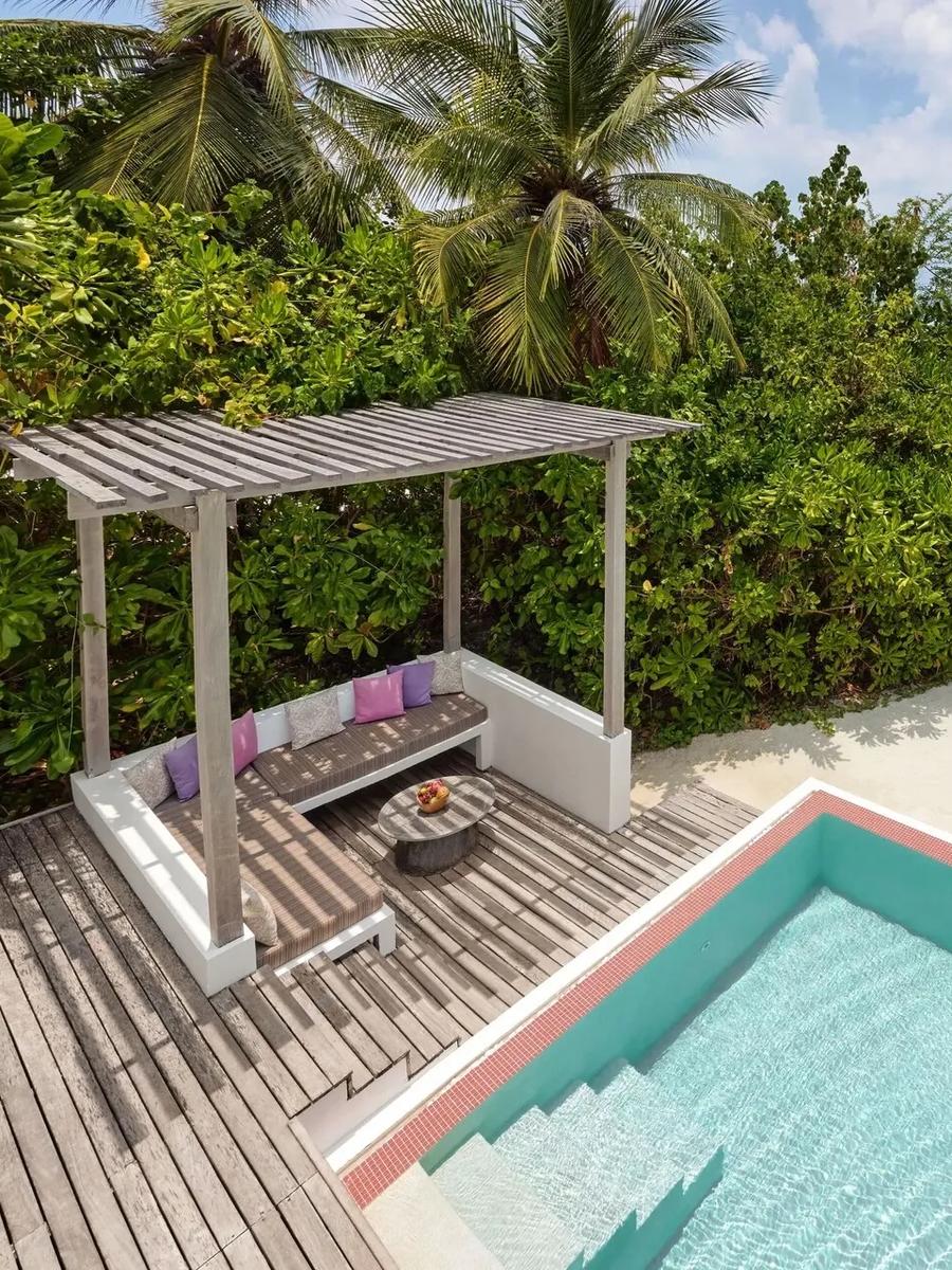 A private pool and shaded pergola lounge on a One Bedroom Beach Villa's deck, a sandy path leading down to the beach beyond