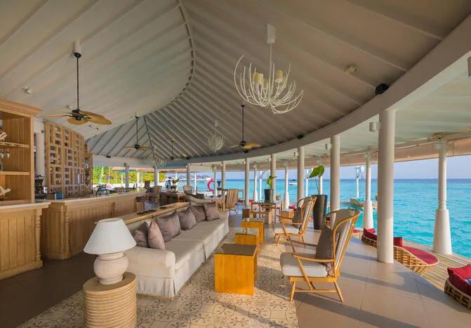 Aqua Bar's open-air lounge deck at the arrival pavilion, seating looking out over the lagoon
